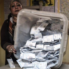 Una miembro de una mesa electoral muestra las papeletas depositadas en una urna en El Cairo.