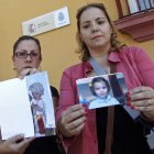 Las tías de los niños desaparecidos muestran sus fotografías a la entrada de la comisaría.