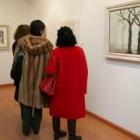 Tres visitantes observan la obra de Virginia Calvo Soler