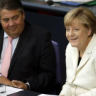 Gabriel (izquierda) y la cancillera Merkel, en una sesión parlamentaria en el Bundestag, en Berlín, este martes.