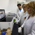 Emiliano Honrado, Engracia Santín y Cristina Díez, delante de uno de los aparatos que se utilizan para los análisis de biopsia líquida.