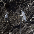 Dos operarios durante la búsqueda de los trabajadores desaparecidos hace un mes.