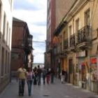 Dos jóvenes caminan junto al edificio que será demolido