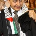 El presidente Zapatero se retira el pañuelo que le colocó un chico