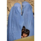 Dos niñas afganas se refugian entre los burkas de sus madres a las afueras de Kabul