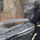 Un bombero del Ayuntamiento de León sofoca un incendio en una nave de Valverde de la Virgen. MARCIANO PÉREZ