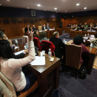 La concejala socialista, en primer plano, manifestando su abstención en la votación.
