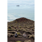 Dos turistas observan el buque español de oceanografía.