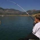 Un niño se inicia en el deporte de la pesca en las orilla del embalse de Los Barrios de Luna