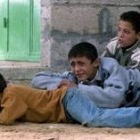 Tres niños se refugian de los disparos del Ejército israelí en Gaza