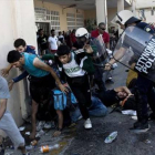 La policía reprime a refugiados en el puerto de Mitilene, ayer.