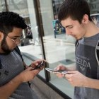 Dos jóvenes usando la nueva aplicación para móviles Pokémon Go.