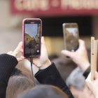 Varias personas captan con sus móviles imágenes de la Semana Santa leonesa. MARCIANO PÉREZ