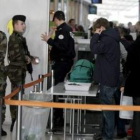 Varios soldados franceses vigilan una de los colas de pasajeros.
