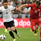 El delantero alemán Ozil intenta escaparse de la marca de un defensa polaco. CRISTOPHE