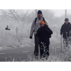 Tres peregrinos se dirigen por el Camino de Santiago a Villafranca en medio de una impresionante helada matinal.