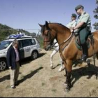 El subdelegado del Gobierno charla con dos de los agentes que vigilan el yacimiento a caballo