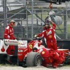 Operarios de Ferrari preparan el coche de Alonso para que sea remolcado feura de pista, en Mugello, Italia.