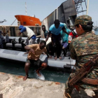 Inmigrantes llegan a la base naval libia después de haber sido rescatados por guardacostas libios en la costa de Trípoli.