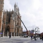 Una gigantesca grúa comenzó ayer a desmantelar la marquesina instalada en la fachada sur de la Catedral. JAVIER FERNÁNDEZ ZARDÓN