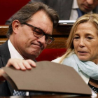Artur Mas mira bajo una carpeta en el Parlament, junto a la vicepresidenta Joana Ortega.