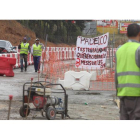 Un grupo de obreros en la avenida de Astorga de Ponferrada junto a una pancarta en la que reclaman sus salarios a la empresa.