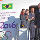 El presidente del Comite Olímpico Brasileño, Carlos Arthur Nuzman, transporta la linterna con el fuego olímpico a su llegada a Brasilia.