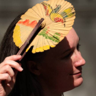 Una mujer se protege del sol con un abanico.  NEIL HALL