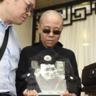 Liu Xia, esposa del premio Nobel de la Paz fallecido Liu Xiaobo, muestra una foto de su marido en día del funeral.