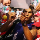 Nadal firma autógrafos tras su derrota ante Djokovic.