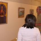 Dos visitantes de la exposición contemplan una de las pinturas