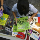 Dos niñas revisan unos libros de texto depositados sobre una mesa.