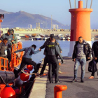 Un agente de la Guardia Civil ayuda a un inmigrante a desembarcar en el puerto de Motril.