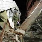 Un militar indonesio constata los daños de un edificio destruido por la fortaleza del seísmo sufrido