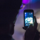 Un usuario utilizando su teléfono móvil durante la noche.