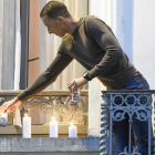 El hermano de Salah Abdeslam, principal sospechoso de los atentados de París, Mohammed Abdeslam enciende unas velas en su balcón sumándose a la vigilia de miles de residentes del barrio bruselense de Molenbeek en contra de los atentados de París