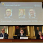 El secretario permanente de la Real Academia de las Ciencias, Göran K. Hansson (abajo, c), anuncia a los galardonados con Premio Nobel de Física, Rainer Weiss, Barry C. Barrish y Kip S. Thorne (en la pantalla, i-d), en la Academia de las Ciencias Sueca en