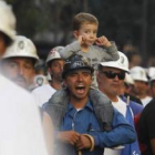 Un niño se tapa los oídos mientras su padre, uno de los mineros de la marcha negra