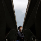 Un hombre con masacarilla bajo un puente en Singapur. HOW HWEE YOUNG