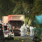 Un grupo de forenses examinan el camión del atentado de Niza.