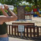 Una joven bebe agua en un parque de Lérida. RAMÓN GABRIEL