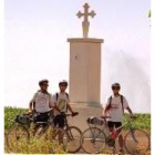 Tres ciclistas junto al monolito erigido en memoria de Millán Bravo