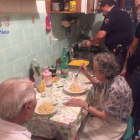 Michele, de espaldas, y Jole comen el plato de pasta que les han preparado los agentes de la policía de Roma.