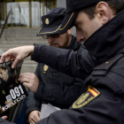Dos policías colocan el cartel en uno de los coches que participan en esta campaña