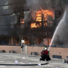 Un bombero intenta apagar el fuego de un edificio del complejo de la alcaldía de Chilpancingo.