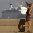 Una mujer corre por el Malecón mientras el crucero Thomson Dream llega a La Habana, el 19 de marzo.
