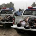 Policías iraquíes recogen los cuerpos de los asesinados en Bagdad