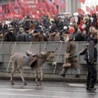 Un joven ucraniano pasa con su burro por delante de una protesta contra  Yushchenko
