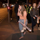 Asistentes al concierto de Ariana Grande salen tras la explosión en el Manchester Arena.