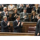Los diputados populares aplauden a Mariano Rajoy (d) tras su discurso en la primera sesión del debate para su investidura como presidente del Gobierno, este mediodía en el Congreso.